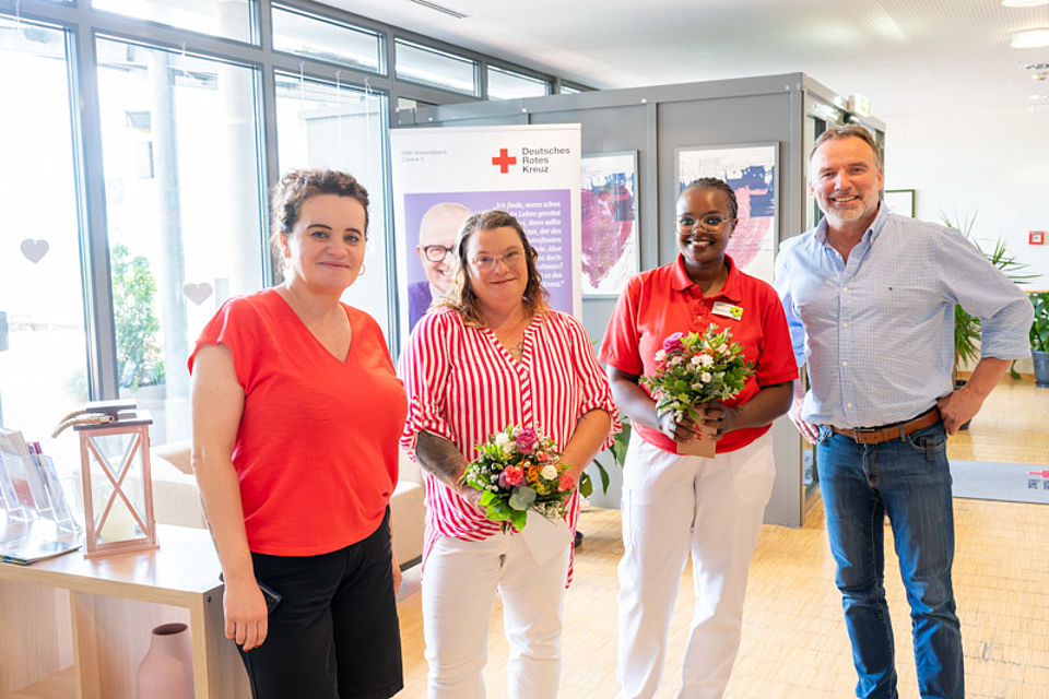 Fertige Pflegekräfte Vier Menschen im Pflegezentrum, in der Mitte zwei Angestellte, daneben die Einrichtungsleiterin und der Fachbereichsleiter.