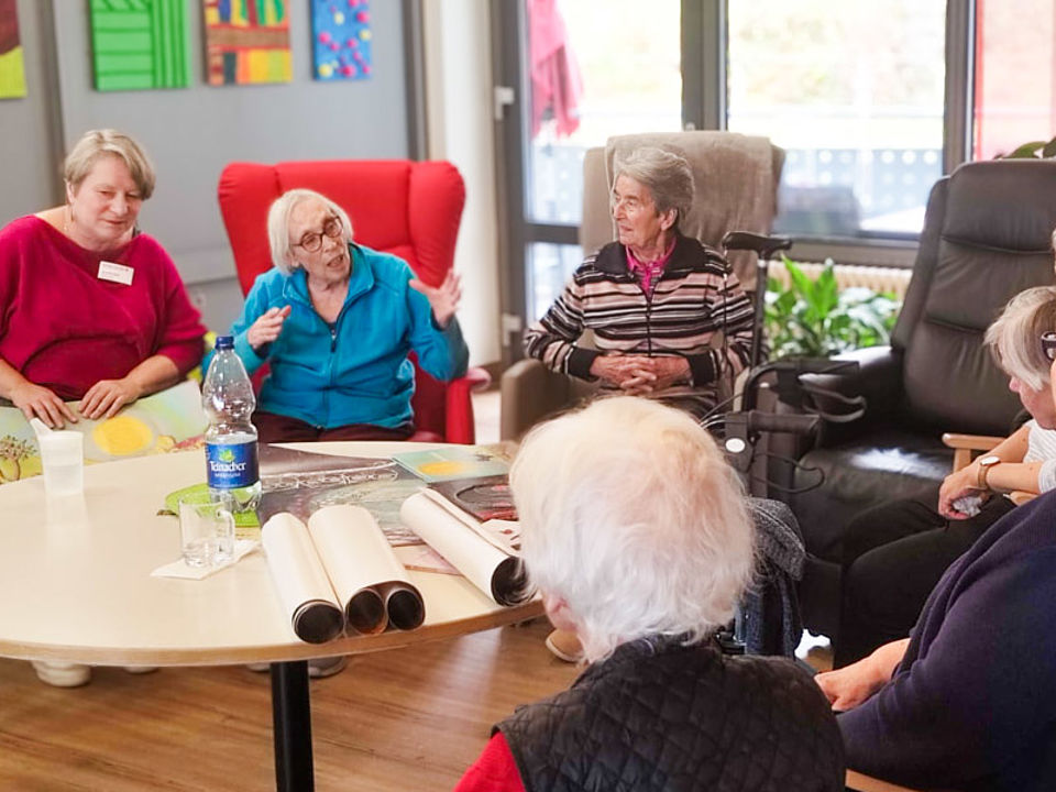 einige ältere Personen im Pfegezentrum auf Sesseln im Gespräch